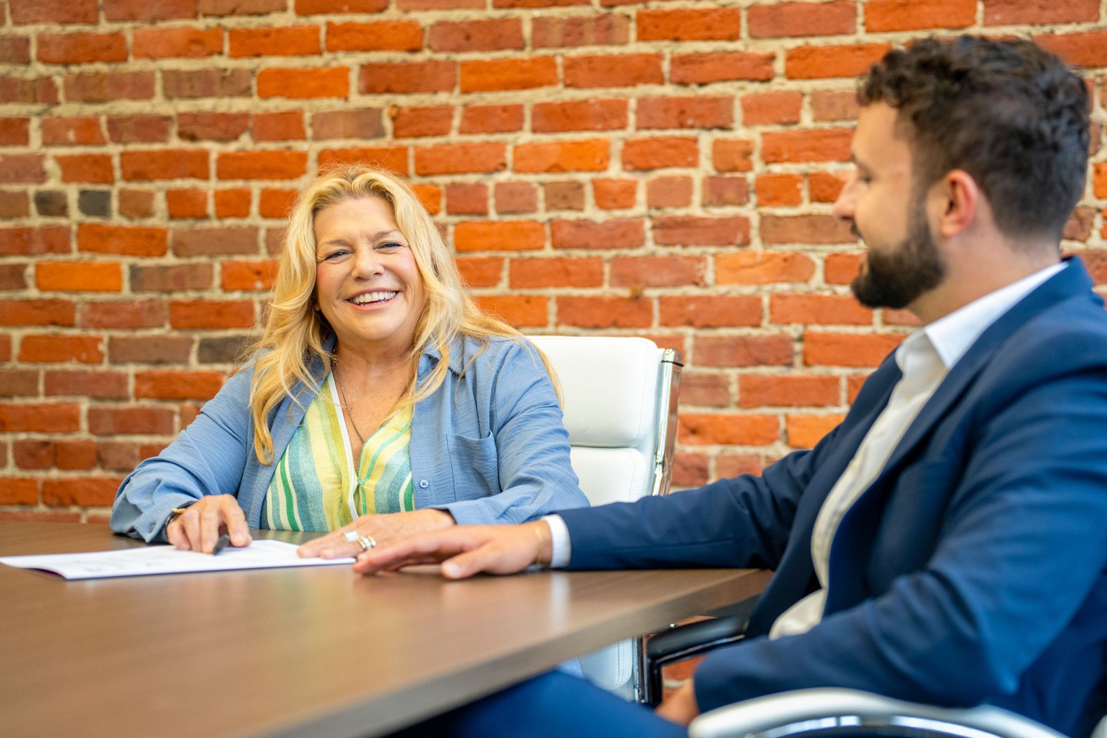 Lori Bakken and Casey McQuery talking at a conference table